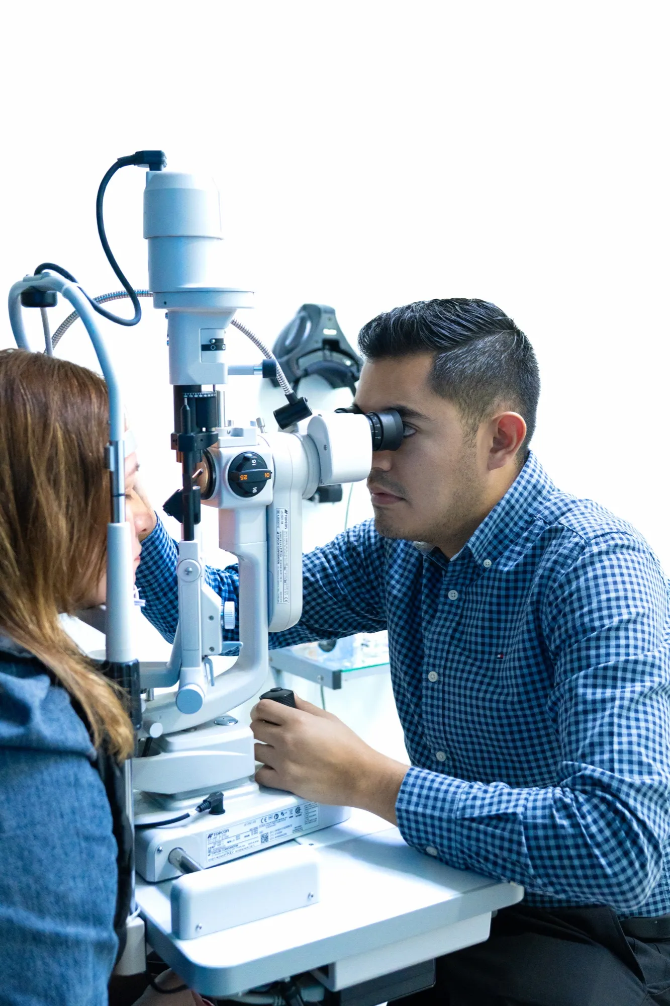 El Dr. Roberto Cervantes explora a una paciente con lámpara de hendidura en EyeCare