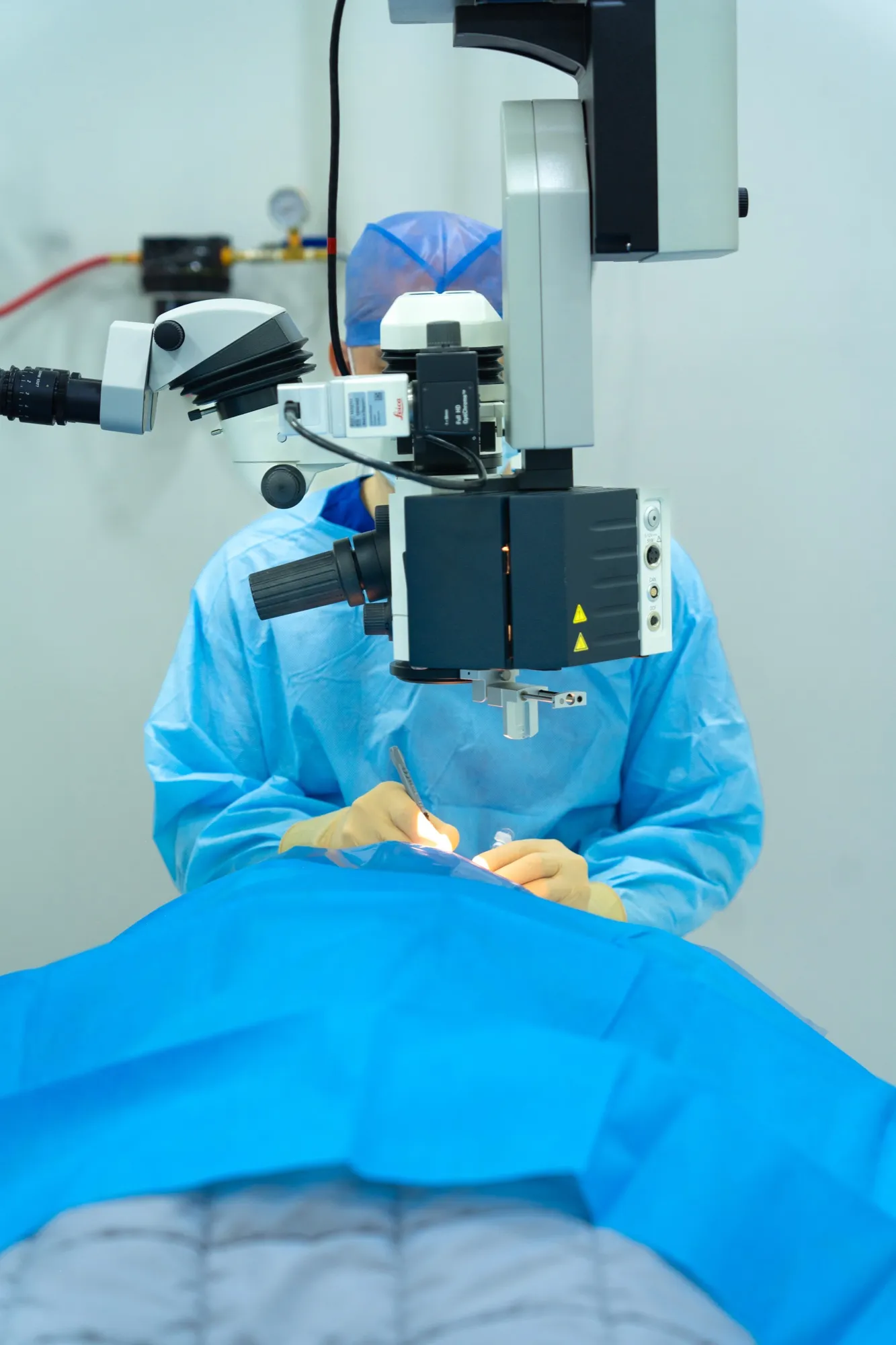El Dr. César Hernández opera con microscopio quirúrgico en el quirófano de EyeCare